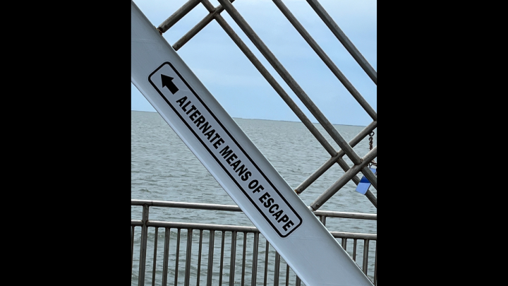 steps on a ferry with alternate means of escape sign